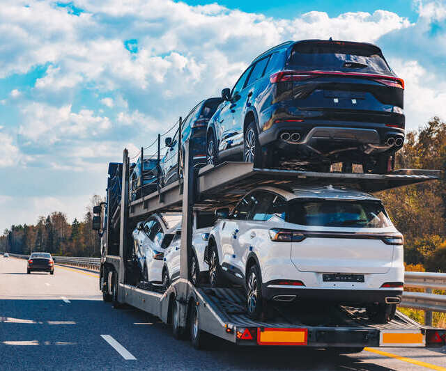 Auto transport driver loading a vehicle onto a carrier trailer